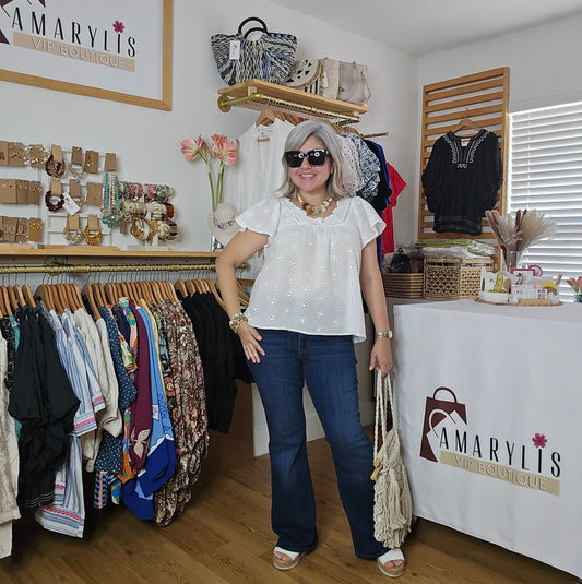 Woman in white shirt and blue jeans walking through a clothing store with 'Amaryllis' branding.