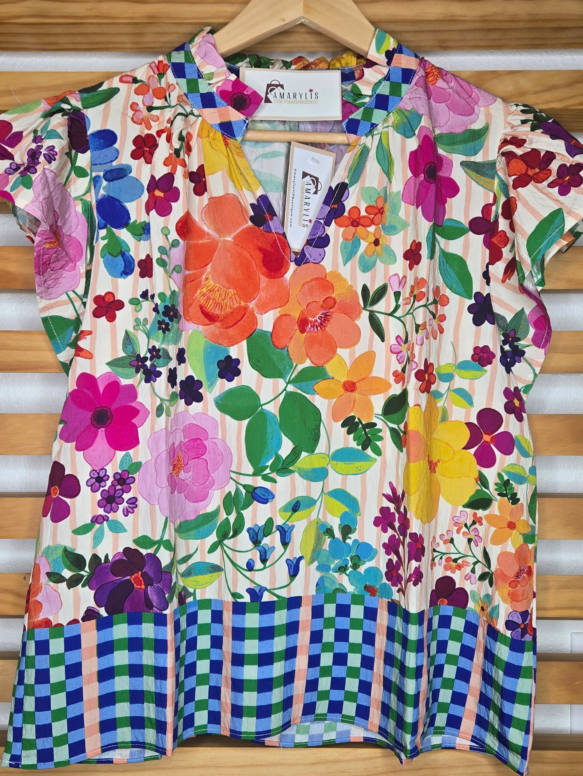 Lightweight blouse featuring soft flutter sleeves and a delicate floral border print. Designed with a feminine ruffled V-neckline, perfect for an effortless boho-inspired look.