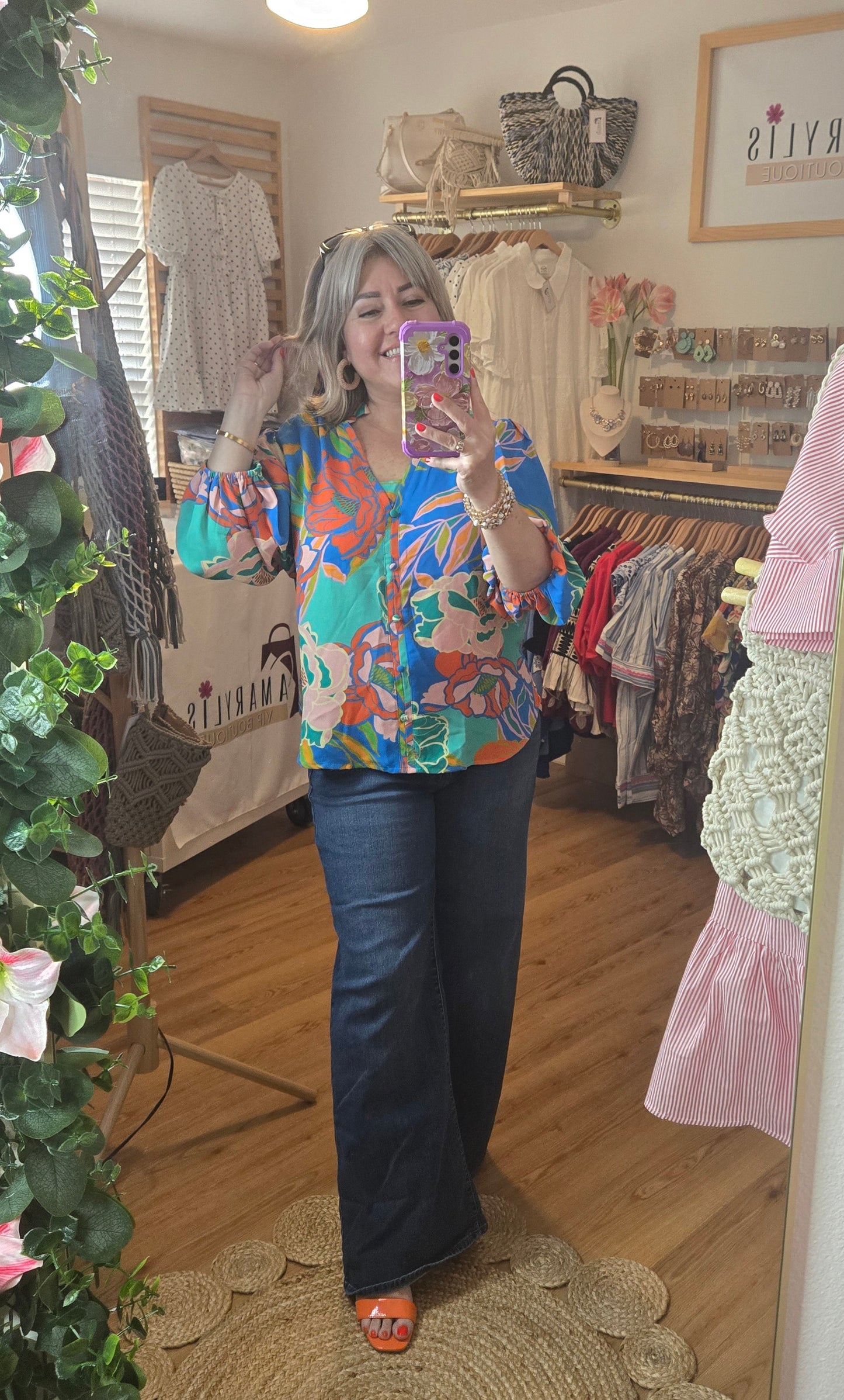 Floral printed blouse featuring 3/4 sleeves and a soft ruffled neckline detail.
