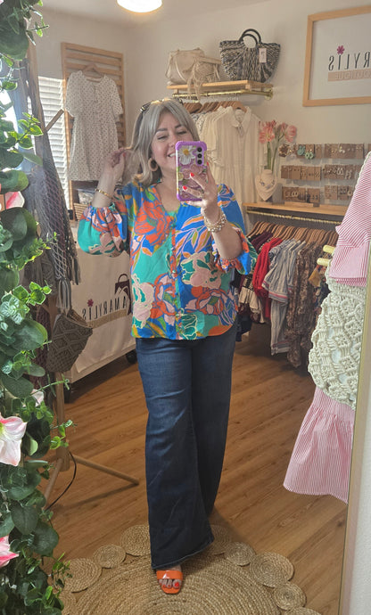 Floral printed blouse featuring 3/4 sleeves and a soft ruffled neckline detail.