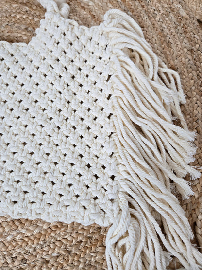 Large woven macrame tote bag with intricate knotted design, long fringe trim, and braided shoulder strap.