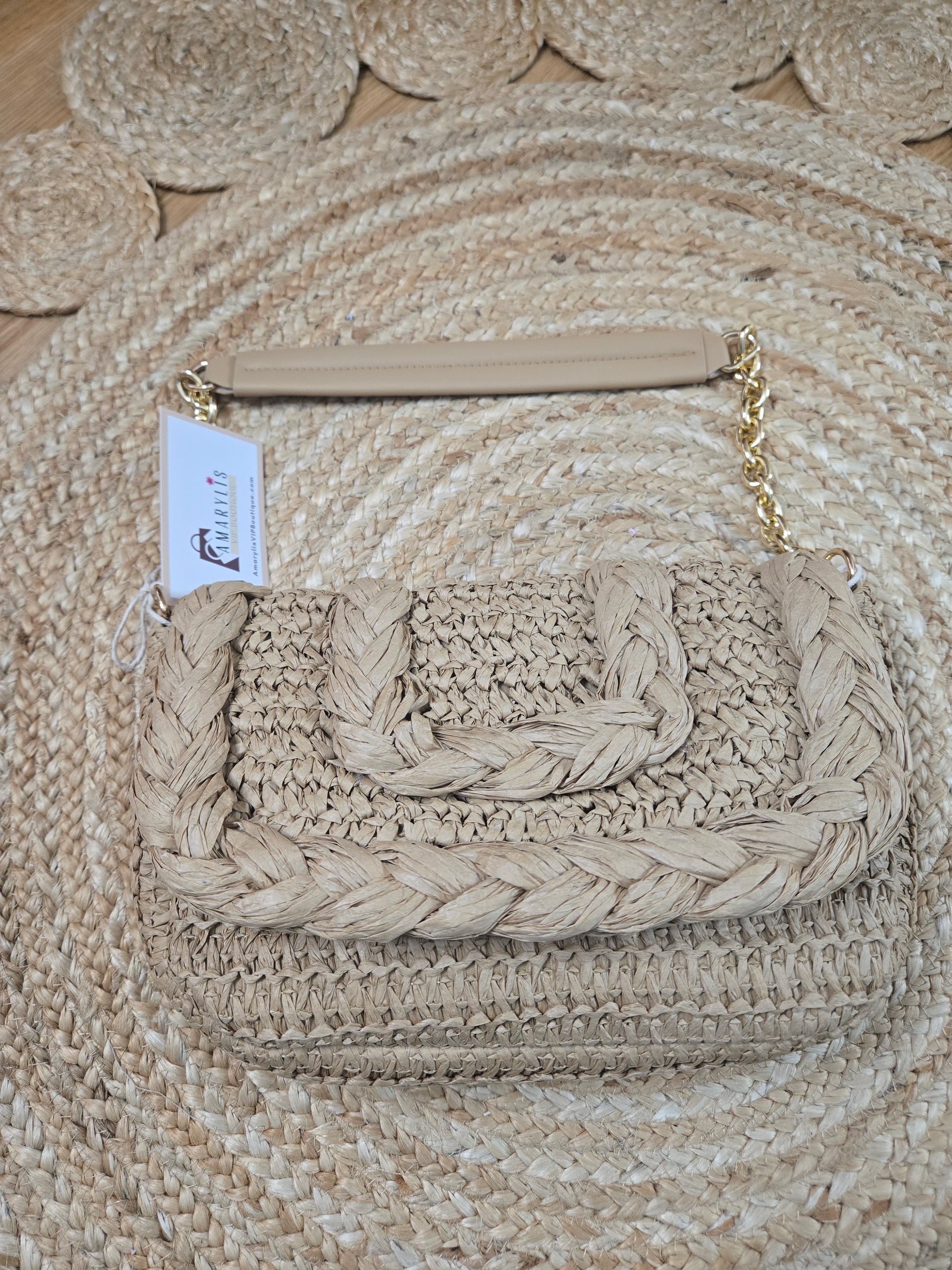Woven raffia flap shoulder bag with textured natural fibers and structured silhouette