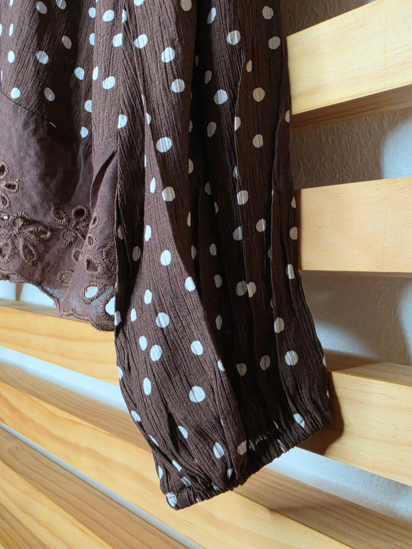 Women's polka dot blouse with scalloped lace neckline, vertical lace inserts, flowing sleeves, button-front closure, and wide eyelet lace hem