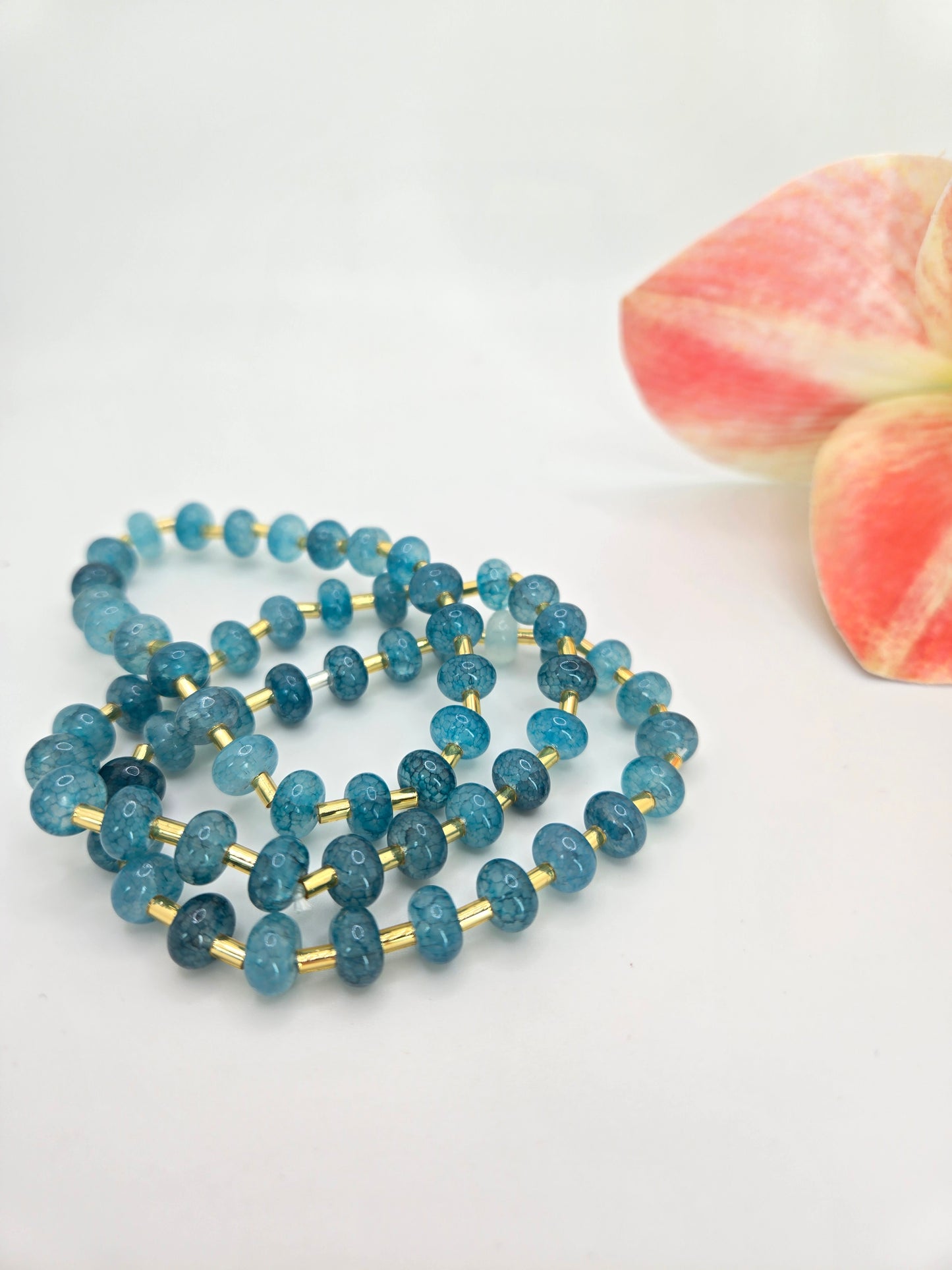 Triple stretch bracelet featuring synthetic marbled stone beads with soft veining and metallic tube accents.