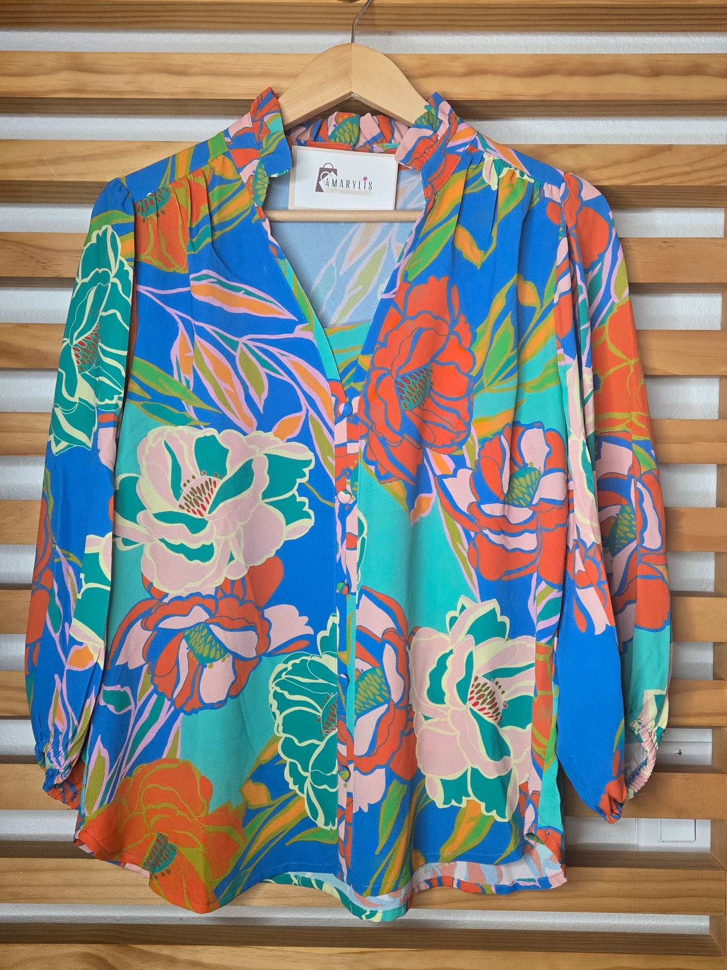 Floral printed blouse featuring 3/4 sleeves and a soft ruffled neckline detail.