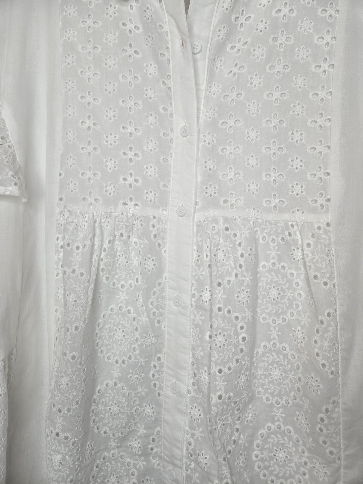 Lightweight shirt dress with eyelet embroidery, button-front closure, short flutter sleeves, and a soft, feminine silhouette.