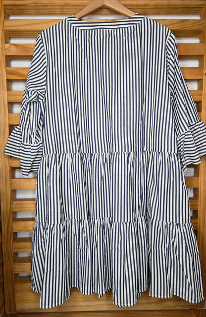 Navy striped cotton babydoll dress with bell sleeves, tassel tie neckline, relaxed fit silhouette, and functional side pockets.