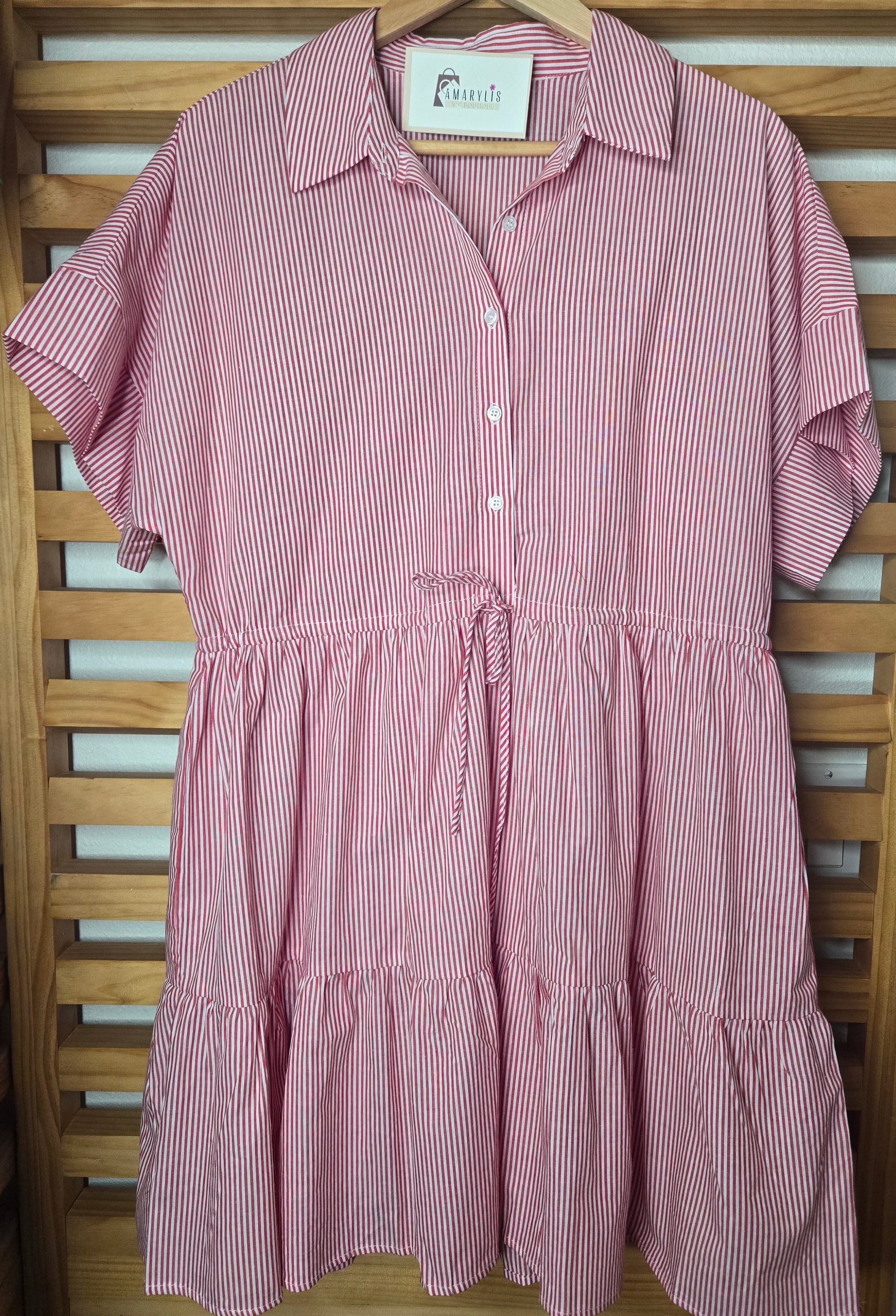 Red striped cotton dress with collared neckline, rolled short sleeves, button front detail, tiered skirt, ruffled hem, and adjustable tie waist.