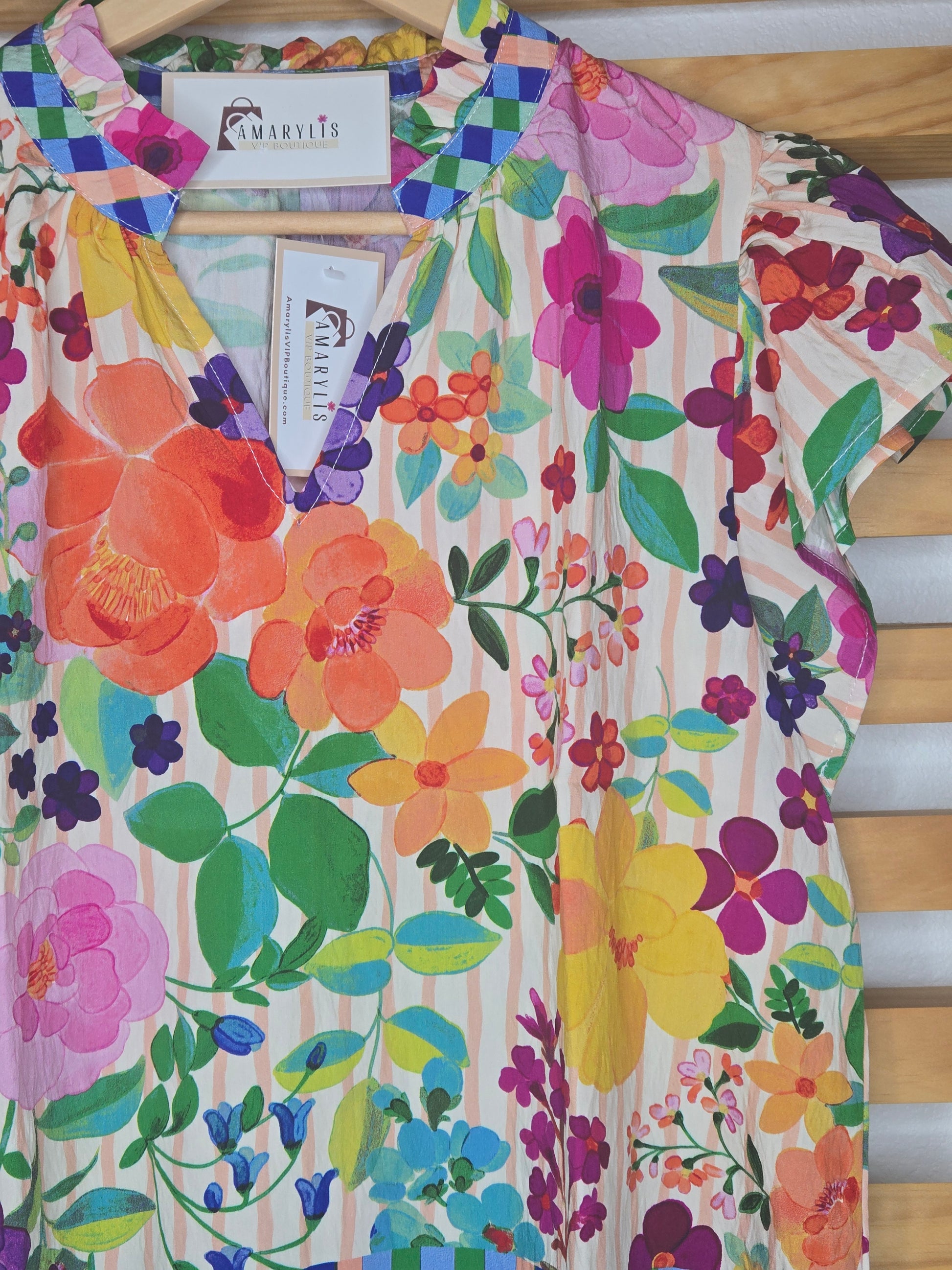 Lightweight blouse featuring soft flutter sleeves and a delicate floral border print. Designed with a feminine ruffled V-neckline, perfect for an effortless boho-inspired look.