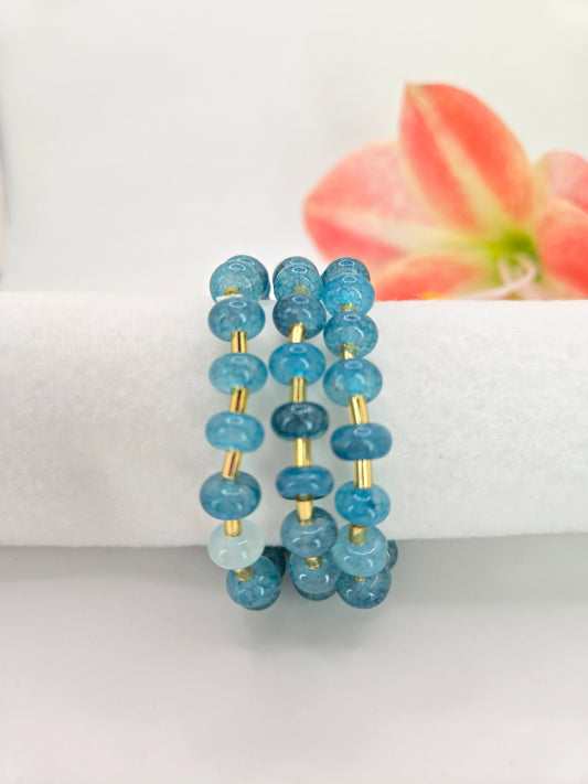 Triple stretch bracelet featuring synthetic marbled stone beads with soft veining and metallic tube accents.
