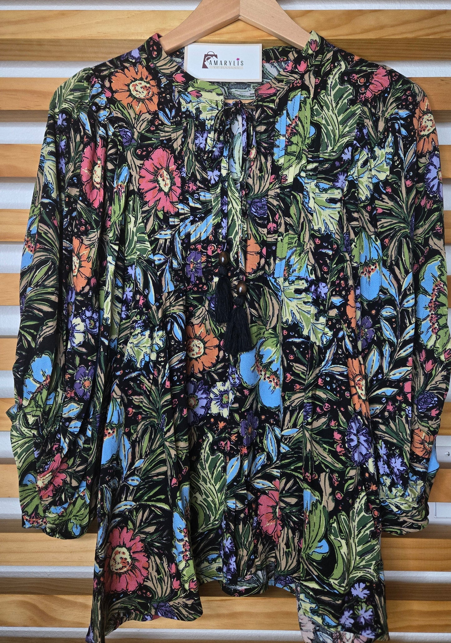 Soft and feminine peasant-style blouse featuring a delicate floral print, 3/4 length puff sleeves, and a tassel-tie neckline. Designed for effortless bohemian looks, this blouse offers a relaxed fit that feels comfortable yet polished and romantic.