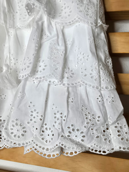 Women's eyelet shorts featuring a tiered ruffle design, elastic waistband, and adjustable tassel drawstring, available in green and white.